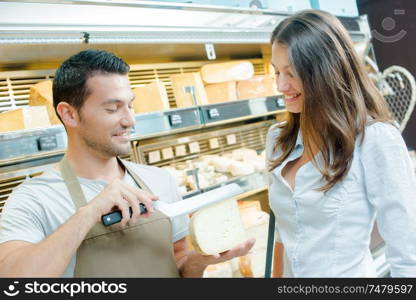 cheese vendor slicing a cheese for customer