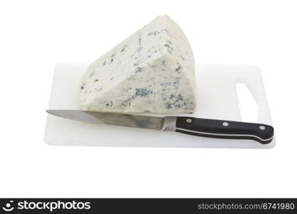 Cheese wedge with knife and cutting board on white background