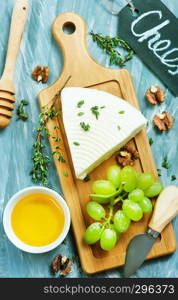 cheese with grape and walnuts on the board