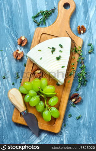 cheese with grape and walnuts on the board