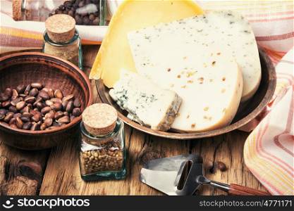 cheese with nuts. Cheese with coriander and nettle on retro wooden background