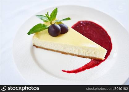 Cheesecake with berry sauce on white plate. Cheesecake with berry sauce