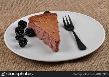 Cheesecake with blackberry on white plate
