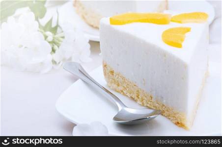 cheesecake with peaches on white plate