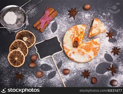 Cheesecake with pumpkin sprinkled with powdered sugar on a black background, top view