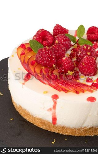 Cheesecake with raspberriees, plum and mint leaves isolated on ehite background
