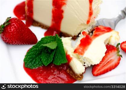 Cheesecake With Strawberry. Slice of cheesecake with fresh strawberries and and a bright red strawberry sauce dripping over the sides on the dessert.