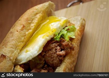 Cheesesteak - sandwich combining frizzled beef, onions, and cheese in a small loaf of bread