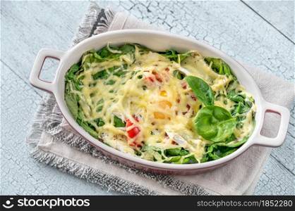 Cheesy baked eggs with spinach and tomato