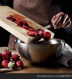 chef adding chopped strawberries bowl