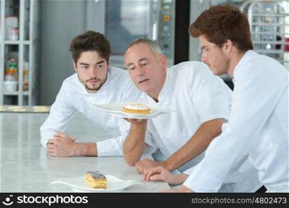Chef and interns looking at cakes