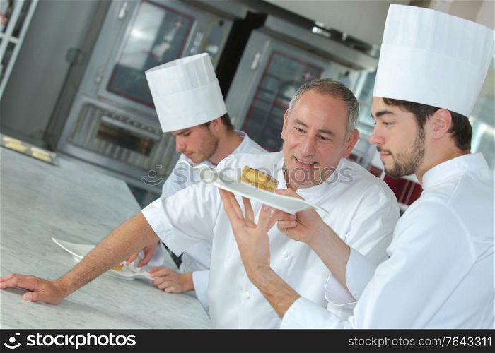 chef approving of trainees dessert creation