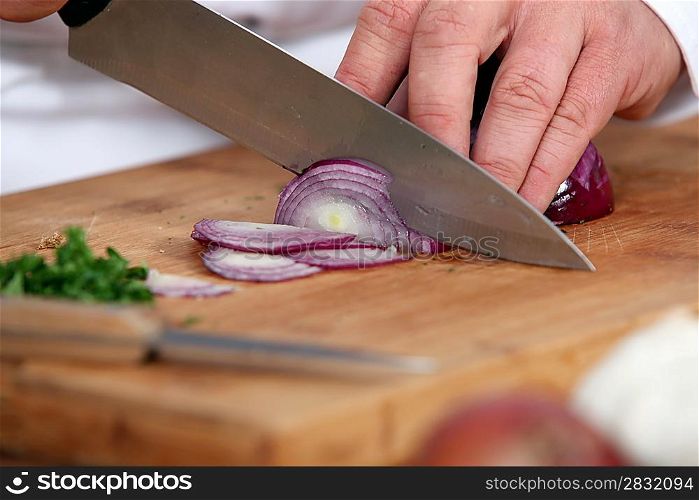 Chef chopping a red onion