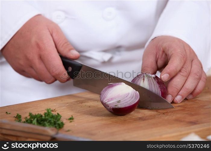 Chef chopping a red onion