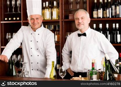 Chef cook and waiter smiling in restaurant wine bar