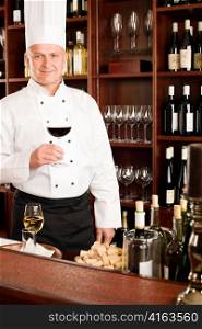 Chef cook hold glass of red wine in restaurant bar
