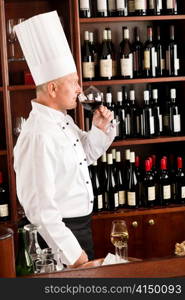 Chef cook smell glass of red wine in restaurant bar