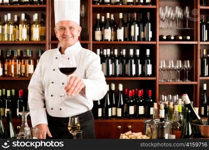 Chef cook smiling serve glass of red wine restaurant bar