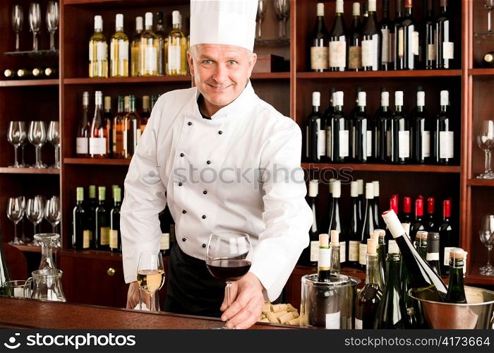 Chef cook smiling serve glass of red wine restaurant bar