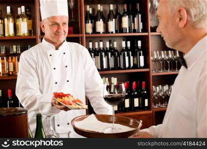 Chef cook with tapas waiter serve on tray in restaurant