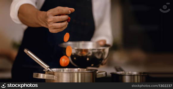 Chef Cooking Food in the Modern Kitchen. Closeup and Selective focus on Hand. Adding Ingredient into the Pot. Male Making Meal