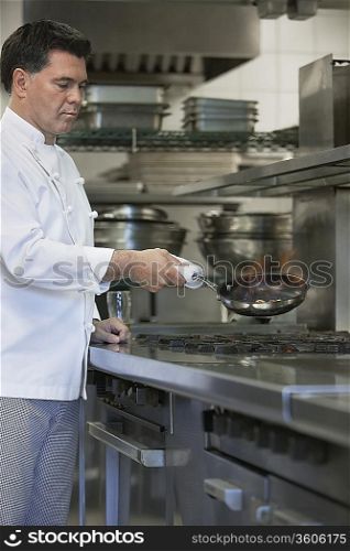 Chef cooking food using frying pan in kitchen