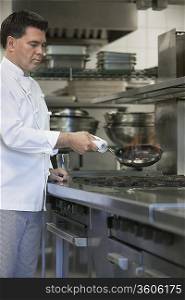 Chef cooking food using frying pan in kitchen