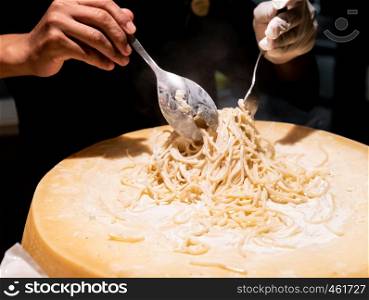 Chef cooking pasta in cheese bowl