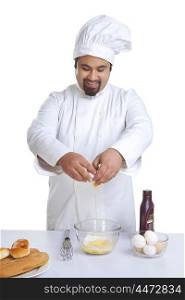 Chef cracking egg into bowl