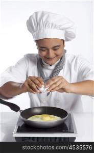 Chef cracking egg into frying pan