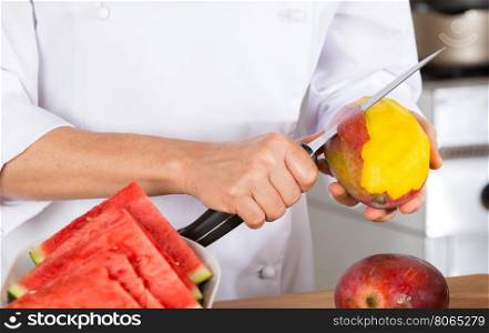 Chef cutting a delicious ripe mango