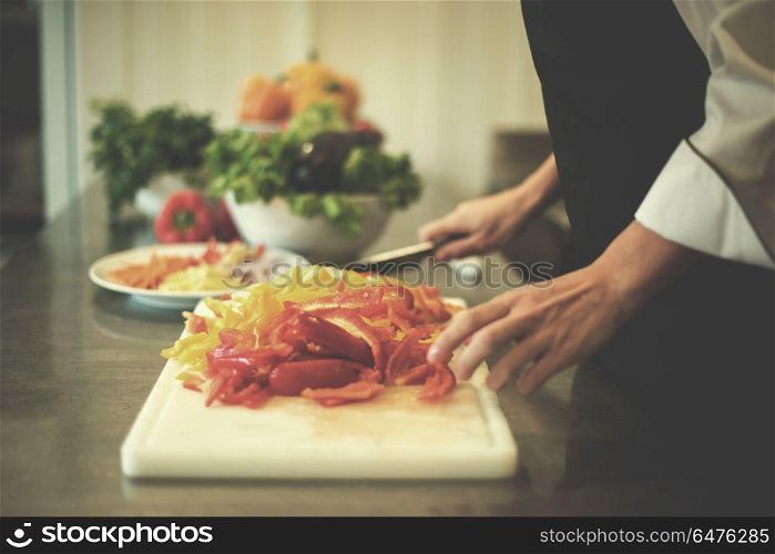 Chef cutting fresh and delicious vegetables for cooking or salad. Chef cutting fresh and delicious vegetables