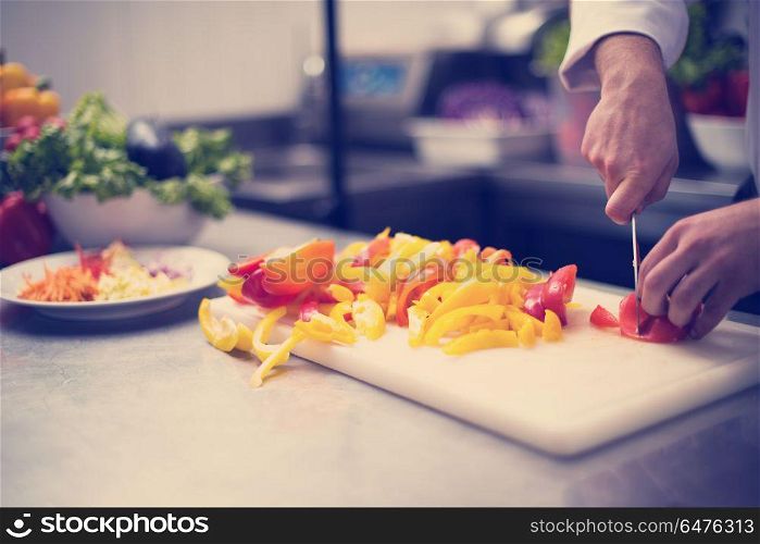 Chef cutting fresh and delicious vegetables for cooking or salad. Chef cutting fresh and delicious vegetables