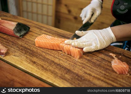 Chef cutting fresh salmon