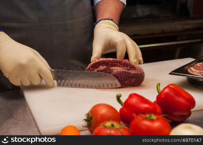 Chef cutting meat. Chef cutting meat on steaks with knife