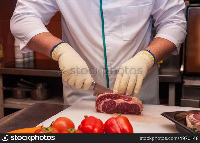 Chef cutting meat. Chef cutting meat on steaks with knife