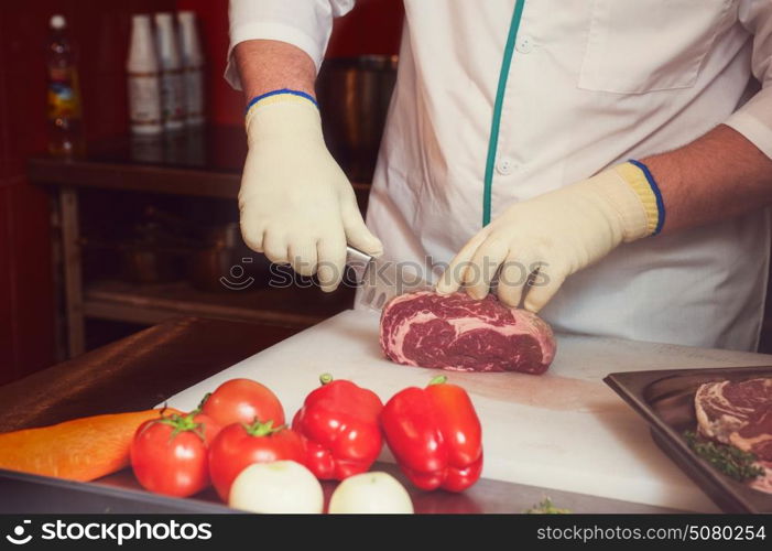 Chef cutting meat. Chef cutting meat on steaks with knife