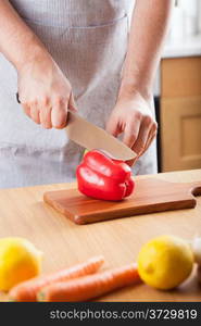 chef cutting paprika in kitchen