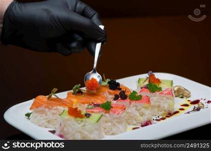 chef decorates sushi with caviar. process of cooking sushi. the process of preparing sushi