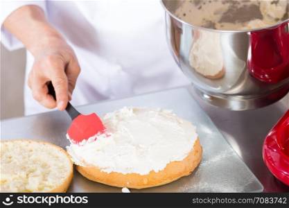 Chef decorating a delicious cake with cream