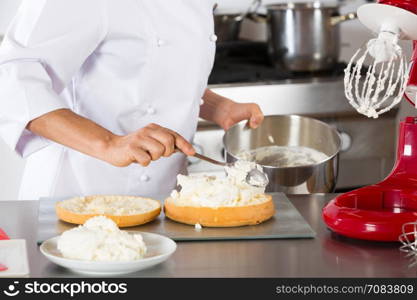 Chef decorating a delicious cake with cream