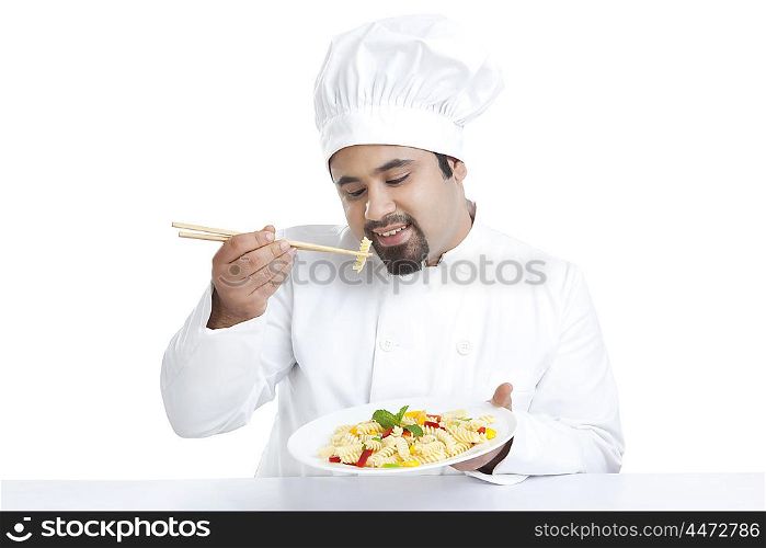 Chef eating pasta with chopsticks