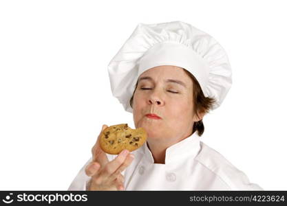 Chef enjoying a delicious chocolate chip cookie she just baked. Isolated on white.