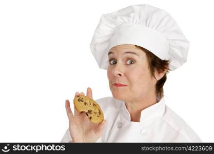 Chef enjoying a delicious fresh baked chocolate chip cookie. Isolated on white.