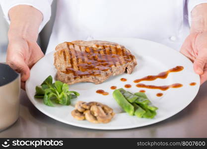 Chef finishing her plate and almost ready to serve at the table