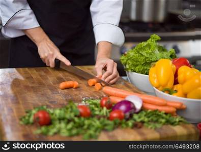 chef hands cutting carrots on a wooden table preparation for meal at restaurant. chef hands cutting carrots