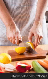 chef hands cutting lemon in kitchen