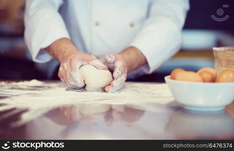 chef hands preparing dough for pizza on table sprinkled with flour closeup. chef hands preparing dough for pizza