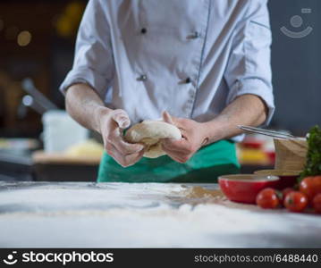 chef hands preparing dough for pizza on table sprinkled with flour closeup. chef hands preparing dough for pizza