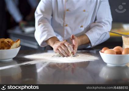 chef hands preparing dough for pizza on table sprinkled with flour closeup. chef hands preparing dough for pizza